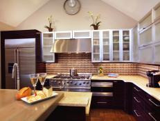Kitchen With Metal Backsplash and Glass-Front Cabinets