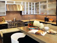 Warm neutrals and browns are used throughout the space to contrast against the sleek style of glass-and-stainless-steel upper cabinets.