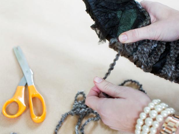 After wrapping fabric around a wreath form, top the wreath with two to three crisscrossed layers of yarn.