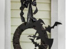 Easily craft this sculptural Halloween wreath that resembles bats taking flight with craft foam, floral wire, fabric and yarn.