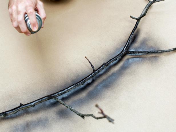 Add two even coats of black matte spray paint to branches, as seen on HGTV.com.