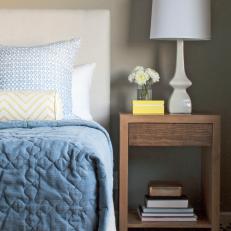 A Contemporary Grey and Blue Bedroom With a Natural Wood Nightstand