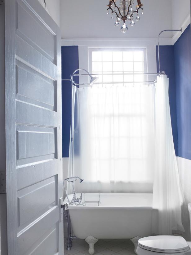 Blue and White Bathroom With Freestanding Bathtub and Chandelier