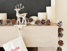Mantel Decorated With Pinecone Garland and Reindeer Stocking Holder