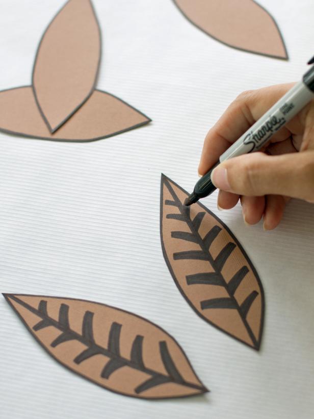 Use a black marker to draw lines on four of the construction paper feathers. This will add a simple detail to your pheasant place cards.