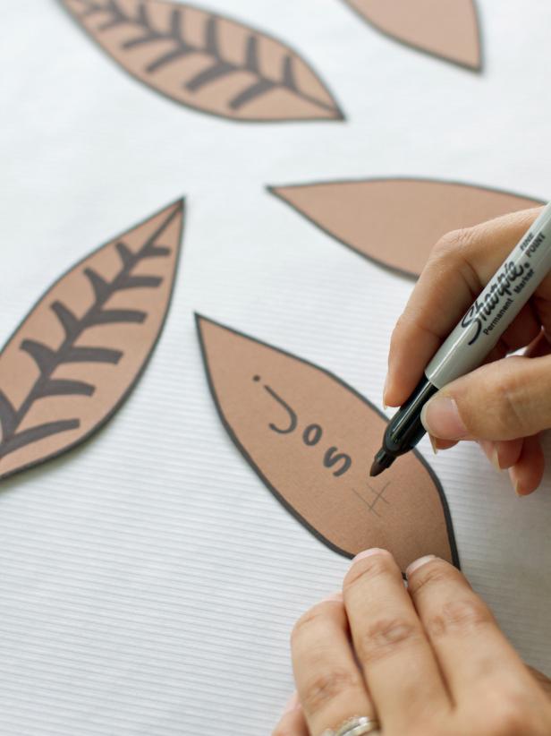 For fun Thanksgiving place cards, write the name of a guest vertically on one construction paper feather.