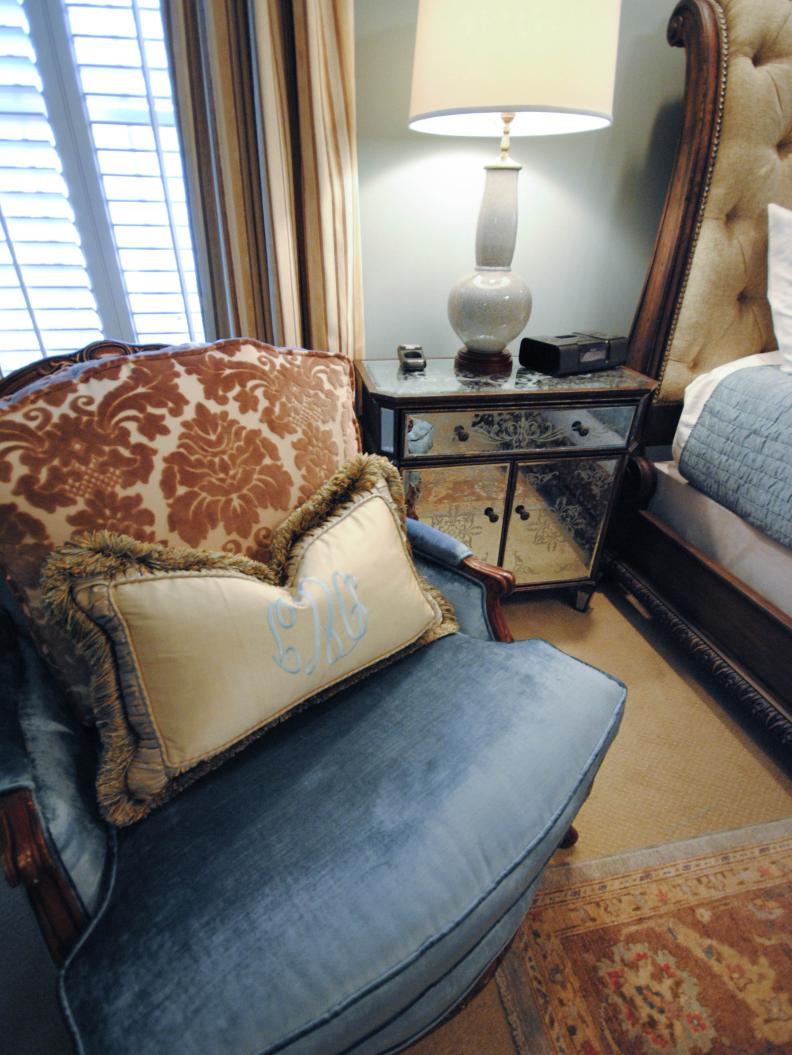 Blue Velvet Chair With Monogrammed Pillow Beside Mirrored NIghstand
