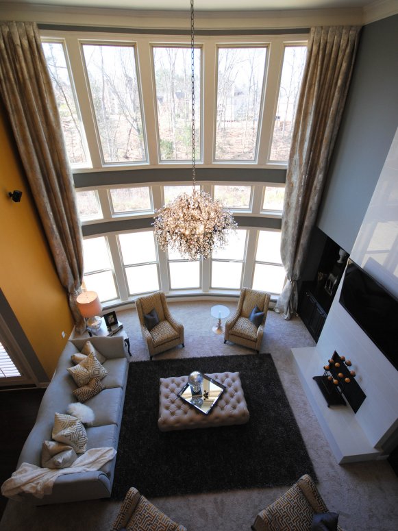 Gray & Yellow Living Room With Two-Story Windows and Chandelier