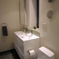 Powder Room With Sleek White Vanity and Green Tile Backsplash