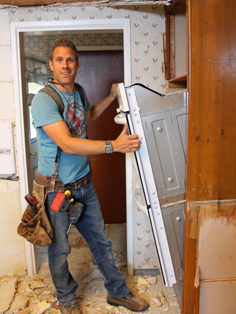 Man removing double oven from cabinet