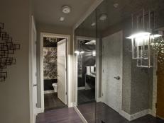 Neutral Foyer With Foxed Mirror Walls and Modern Brushed Nickel Sconce