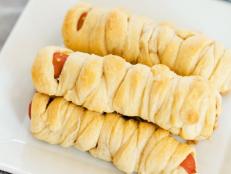 Wrap hot dogs in flaky, ready-made dough to create a Halloween party snack kids will love to help make before gobbling them up.