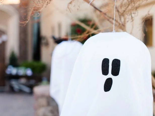 Attach your ghosts with hot glue or fabric glue then hang your ghost from a low tree limb, light post or shepherd's hook.