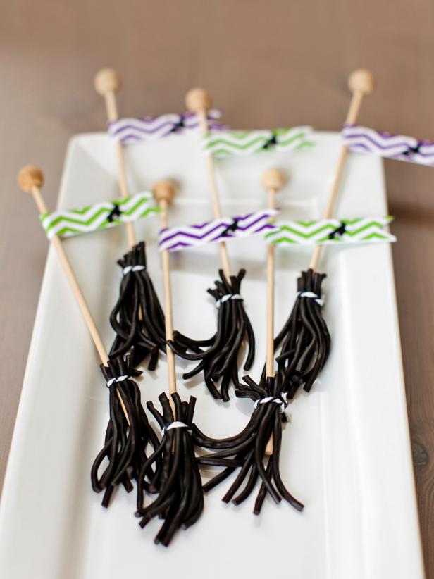 Cut licorice ropes into several short strips, place around rock candy stick and then tie at the top with a small piece of twine. Print flag template onto card stock and then cut out designs and glue a flag to the top of each broom for a cute homemade Halloween treat.