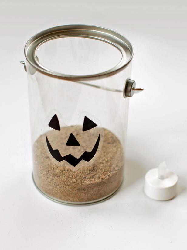 Add sufficient sand to the bottom of paint bucket just prior to adding a battery operated tea light to form your Jack-o'-Lantern luminary.