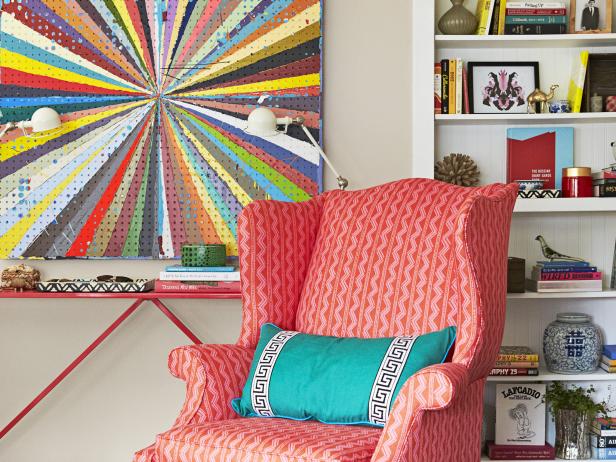 Pink Wingback Chair With Teal Pillow Next to Colorful Pegboard