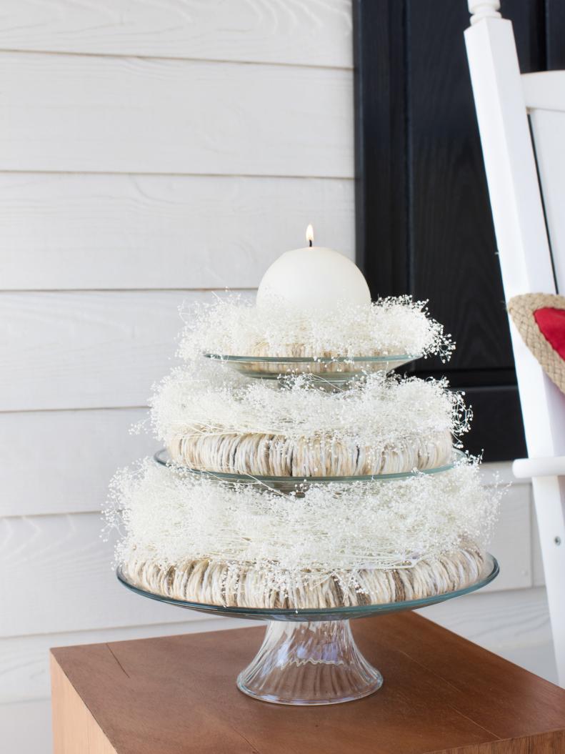 Tiered Glass Serving Stand Topped With Wreaths & White Candle