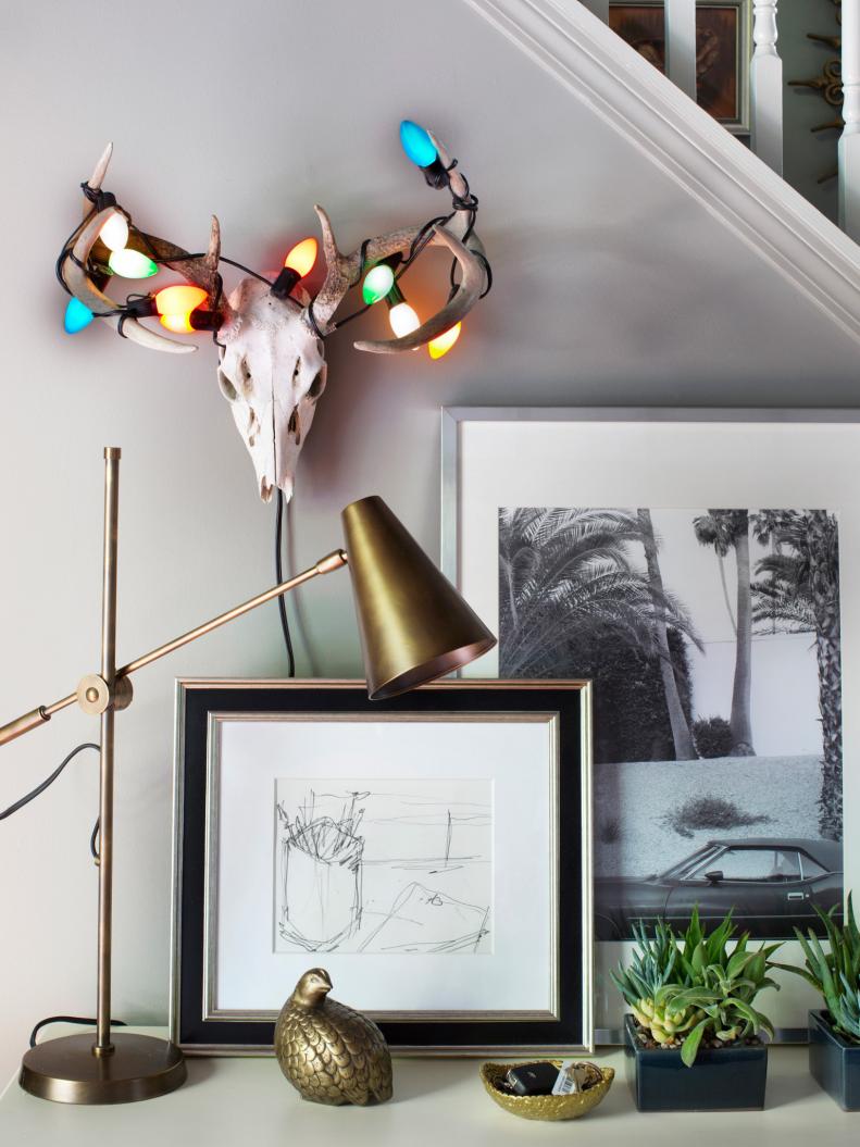 An animal skull and horns with Christmas string lights