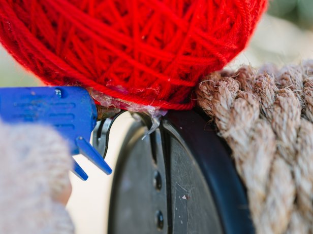 Hot Gluing a Red Yarn Ball onto a Mailbox