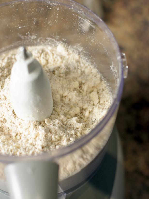 Add flour, nuts, sugar, rosemary, and salt to a food processor. Pulse a few times to mix well. Add cold pieces of butter and pulse until you get pea-sized consistency. Add egg yolk and pulse a few more times until fully combined.