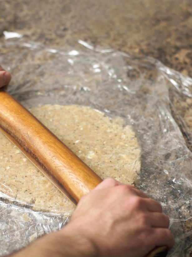 Pour dough into center of a piece of plastic wrap on a flat surface. Bring together the sides and form a disc. Wrap the dough completely with the wrap and place in the refrigerator for at least 30 minutes. Roll dough out on flat surface lightly dusted with flour to just less than 1/4-inch thickness.