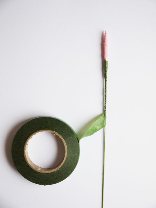 Secure the paper to the floral wire with double-sided tape, and cover the entire wire in it .