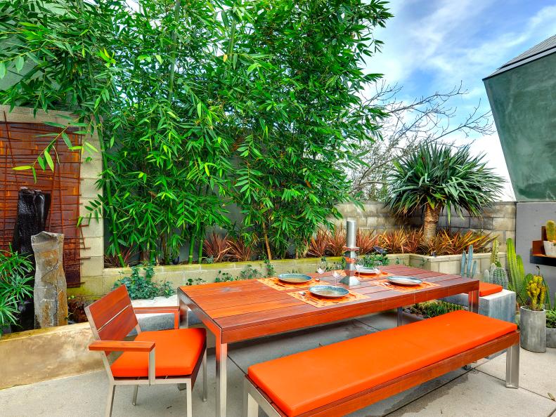 Contemporary Outdoor Dining Area With Orange Dining Table and Bench
