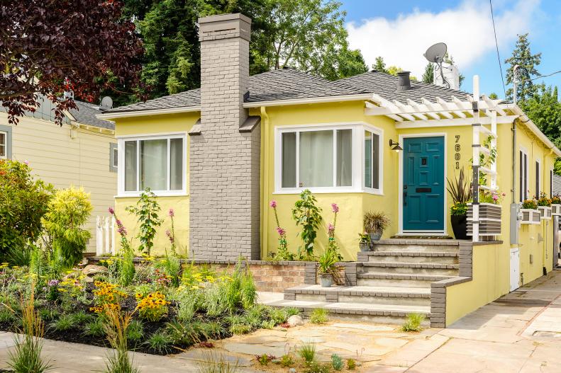 Yellow Home With Gray Chimney, White Pergola, Blue Front Door