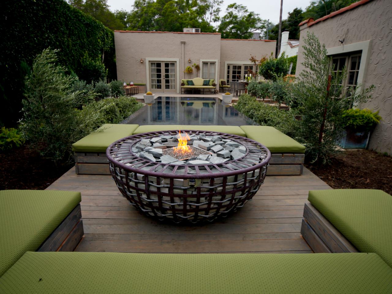 Large Fire Pit In Contemporary Backyard With Green Benches And