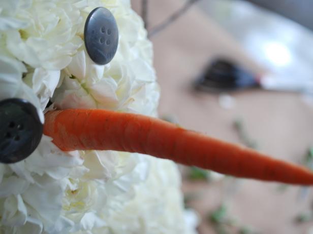 Snap or cut carrot down to four inches in length, then insert six-inch skewer into carrot. Place carrot into center of top sphere for use as a nose.