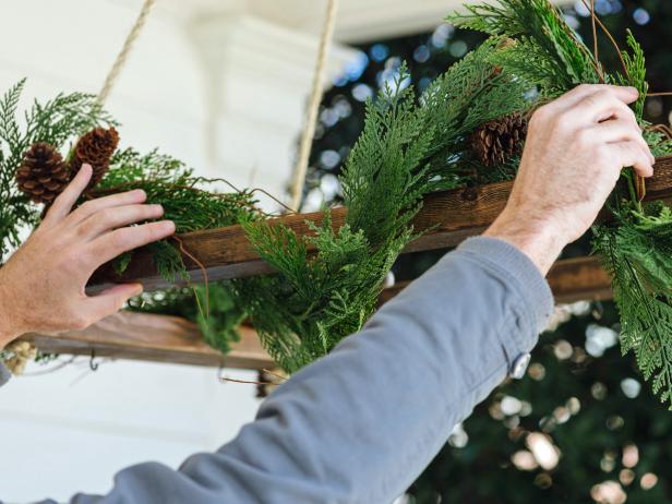 Gather fallen branches with greenery from the yard, or pick up bundles of Christmas tree trimmings from a local Christmas tree lot. Layer trimmings along the top of the chandelier frame, securing them in place with galvanized wire.