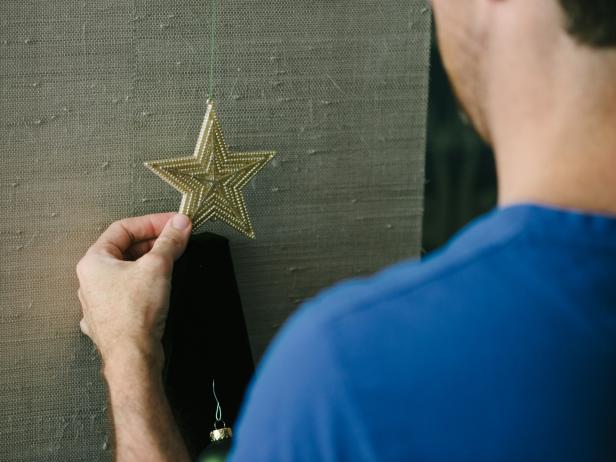 Insert push pin directly into the wall above the triangle tree, then hang star.