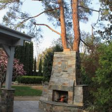 Stone Outdoor Fireplace in Mediterranean Backyard