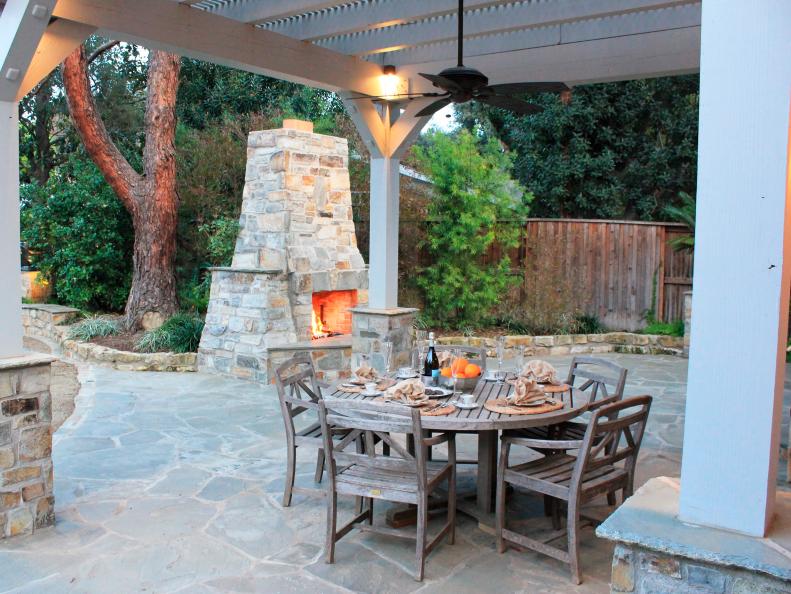 Outdoor Dining Area With Wood Dining Table, Wood Pergola & Fireplace