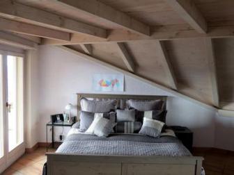 craftsman style bedroom with slanted wood beam ceiling
