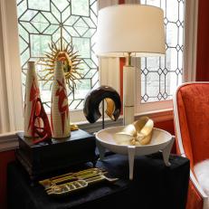 Side Table With Eclectic Objects in Bold Orange Room
