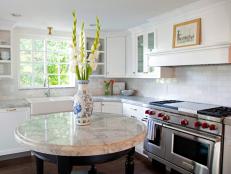White kitchen with a round marble island