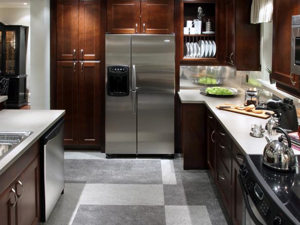 Stainless steel backsplashes are stylish and eco-friendly. Warm wood cabinetry complements a faux (budget friendly) stainless steel backsplash in this bachelor kitchen designed by Candice Olson.