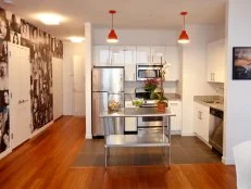 White Kitchen With Photo Wall, Two-Tiered Island & Red Pendant Lights