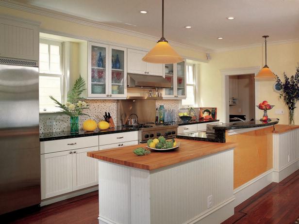 In this appealing kitchen, the designer limited the use of the most expensive materials and employed simple bilateral symmetry to create a fresh and workable room. By putting glass fronts on two of the upper cabinets, he maximizes both light and space. (Design by Andre Rothblatt)