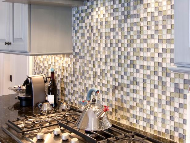 Small green, white, and blue glass tile backsplash in the kitchen behind the stove.