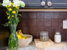 To keep with the copper theme of the Burt's family kitchen, the Kitchen cousins chose to use a hammered copper backsplash  to keep the warm rich tones and bring some texture to this modern kitchen renovation as seen on throughout the kitchen, as seen on HGTV.