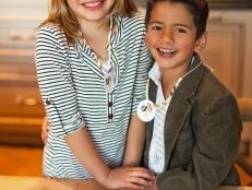 Boy and Girl Wearing Orange and White Straw Necklaces