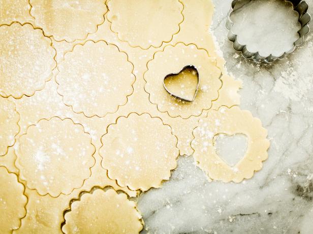 Using a 3-inch fluted round cookie cutter, cut out 3 dozen circles. On only half of the rounds, use a 1-inch heart-shaped cookie cutter to cut out centers; these will be the tops of the finished cookies.