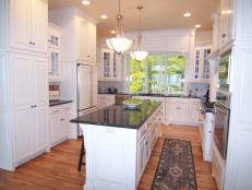 White Kitchen With Black Granite Countertops and Hardwood Floors