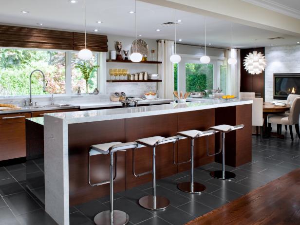 Wide view of kitchen after Candice Olson, host of Divine Design, did a remodel. Wide view of bar area with stools, blinds, shelves, new floor tile, sink area, new lighting.