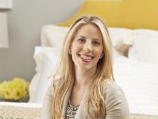Homeowner smiling after her master bedroom makeover at HGTV Magazine.