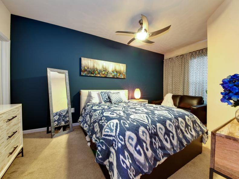Small Angular Bedroom with Blue Accent Wall and Ikat Bedding