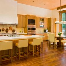 Open-Plan Kitchen With Warm Walnut Cabinetry and Breakfast Nook