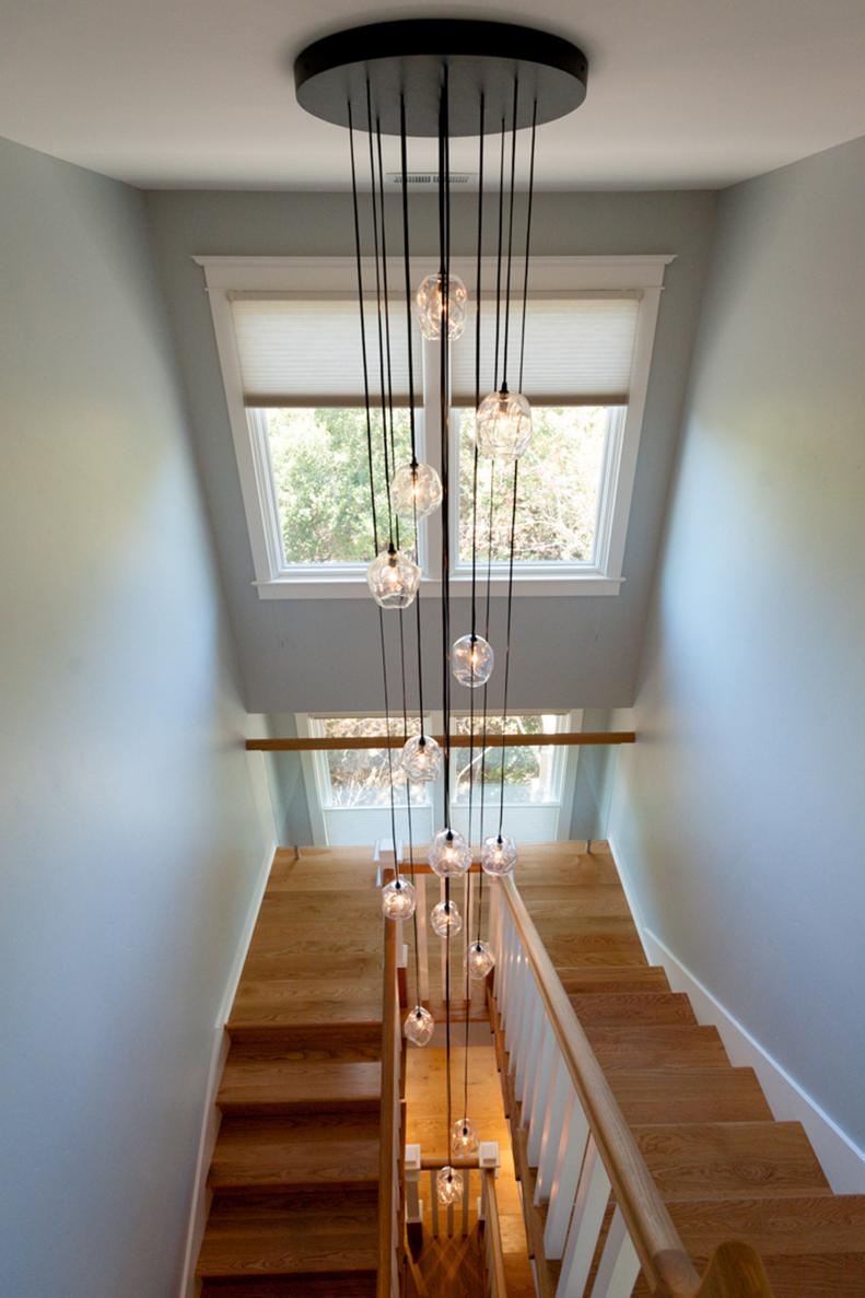 Gray Hallway With Staircase and Glass Pendant Lights